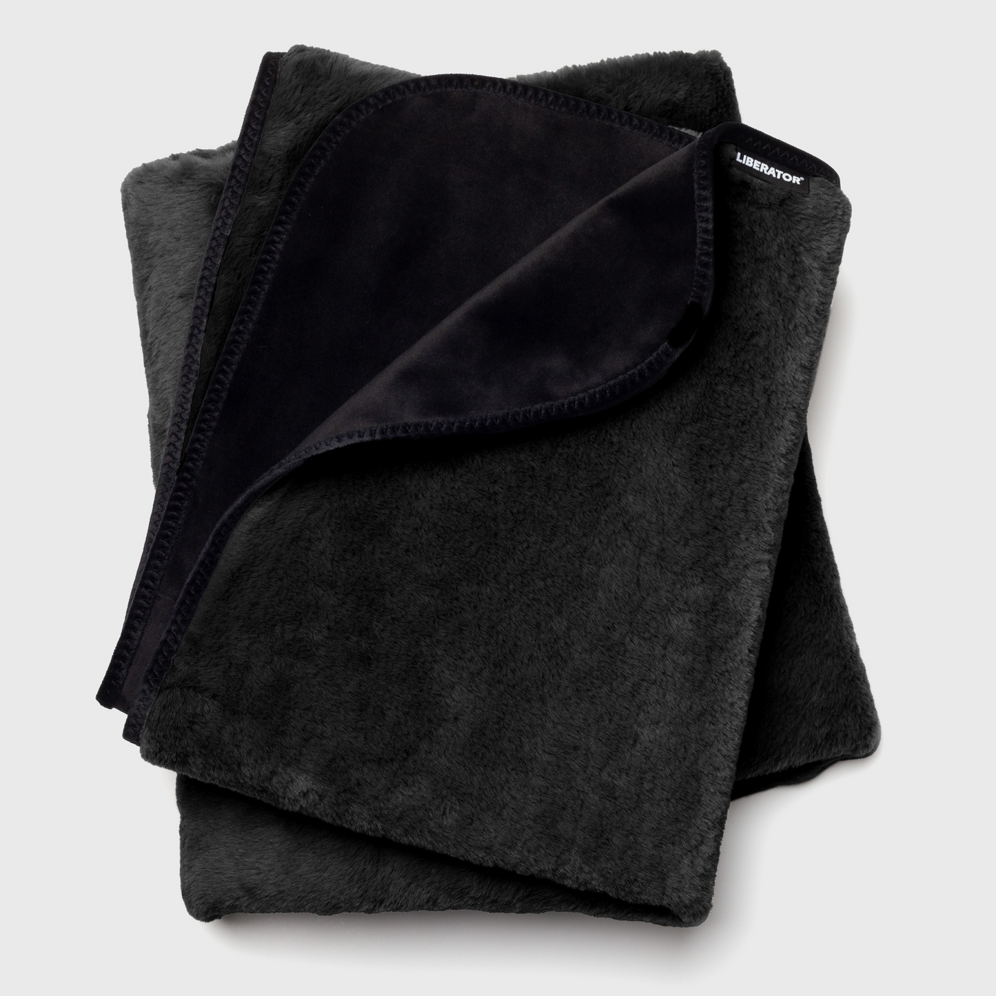 Folded black waterproof blanket on a light gray background